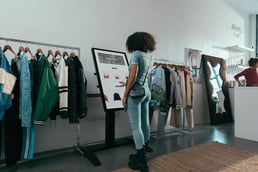 A young woman looks at a ChromeOS digital display in a clothing store