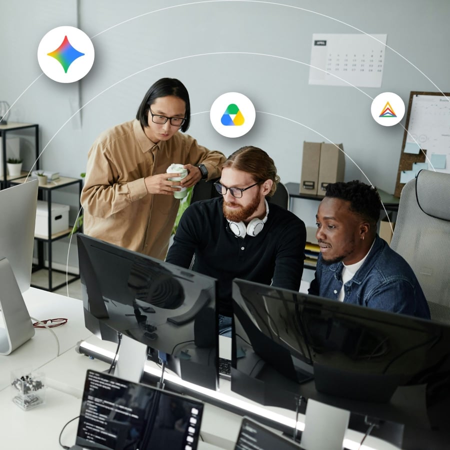 Three men gather around a desktop computer