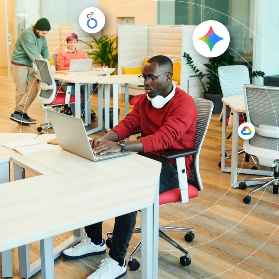 A man types on his laptop in a modern office setting
