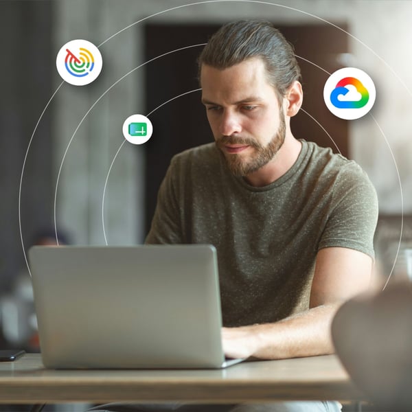 A man working on a laptop with Google Cloud icons overlaid across the image