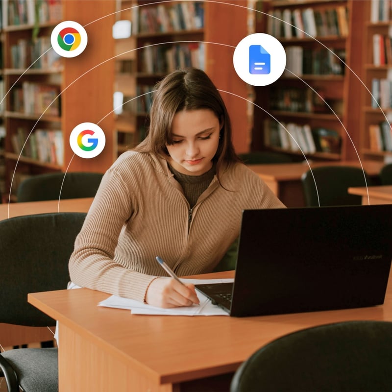 A young college student works on her laptop at a library